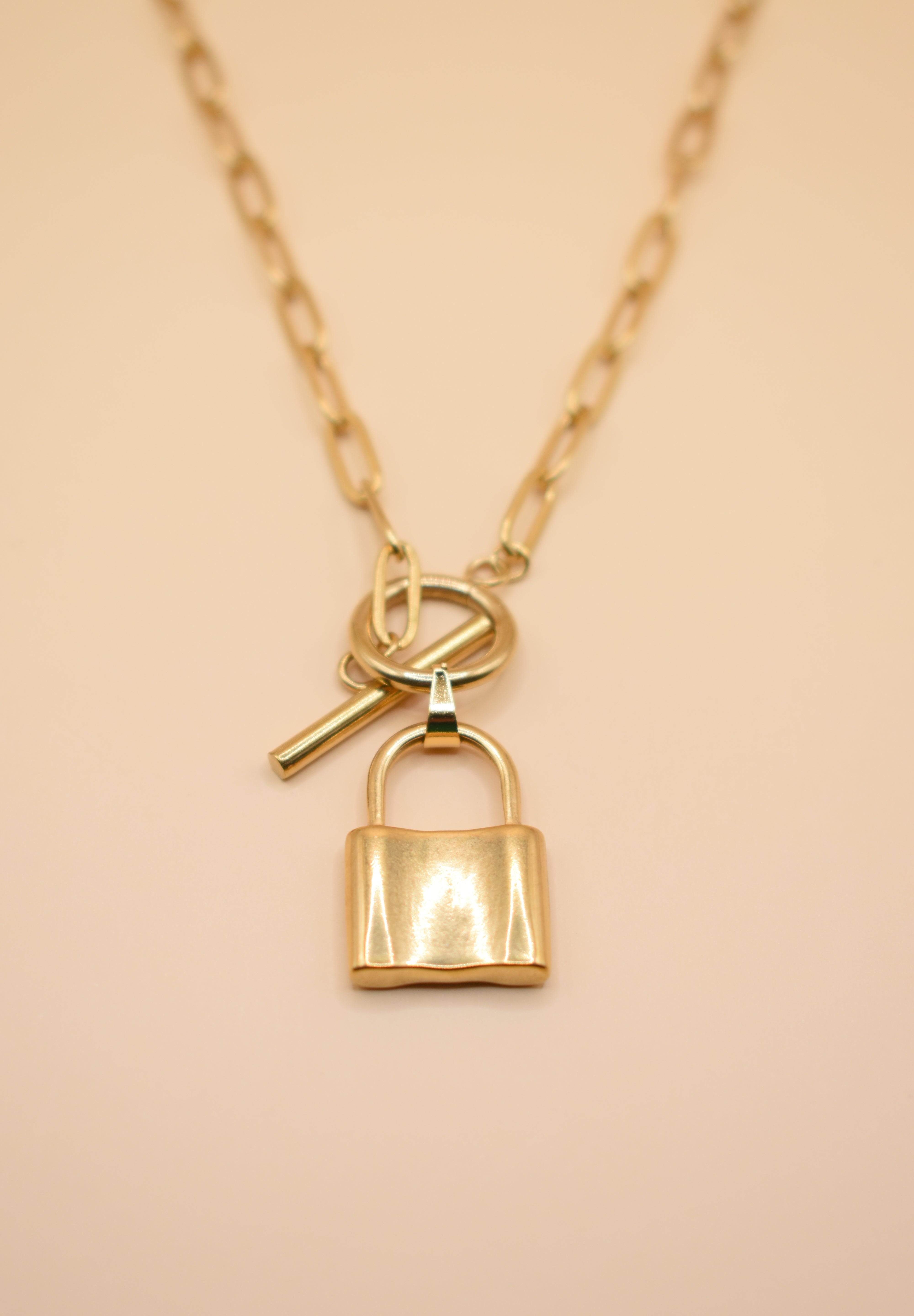 Gold lock pendant necklace on paperclip chain
