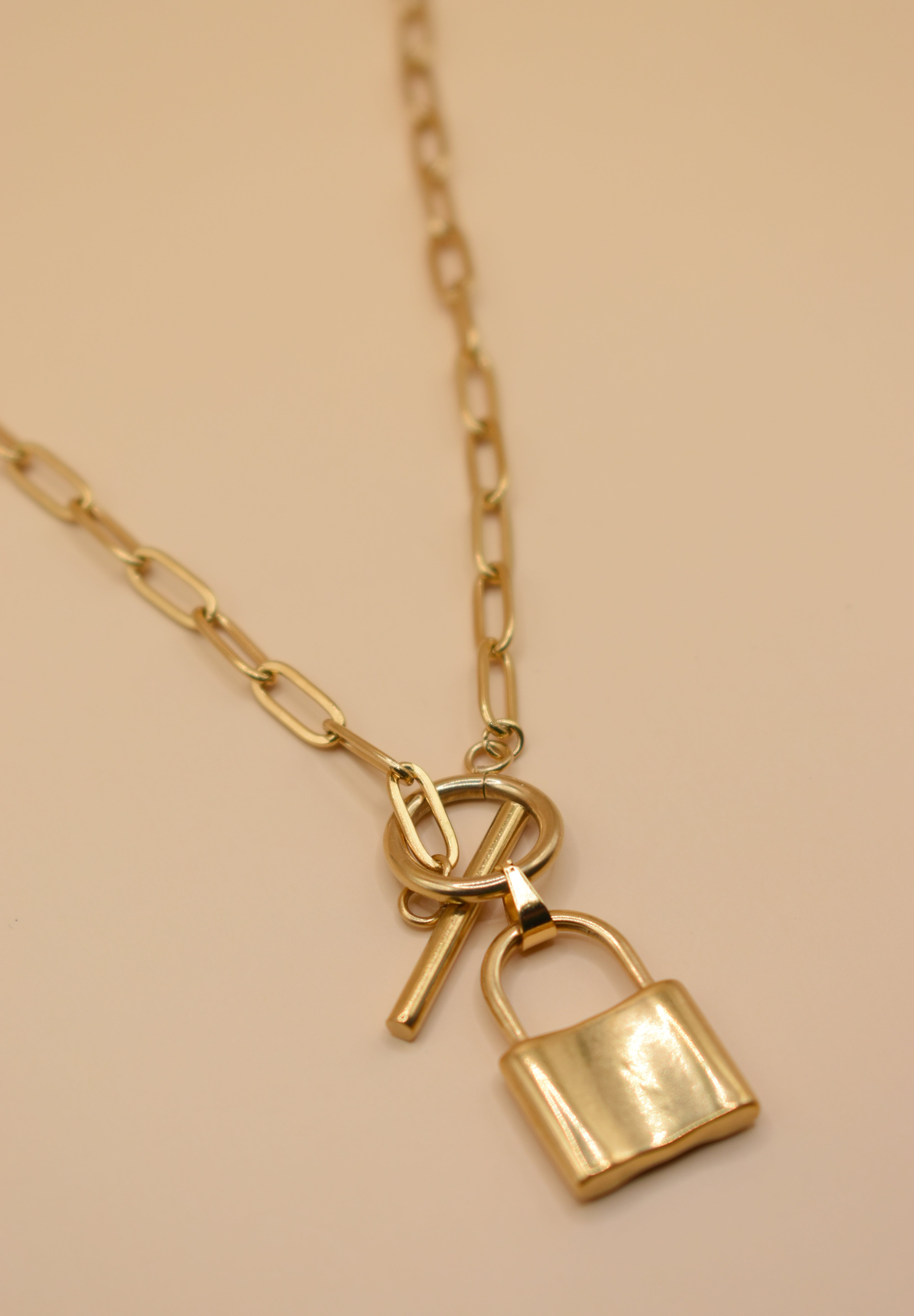 Gold lock pendant necklace on paperclip chain