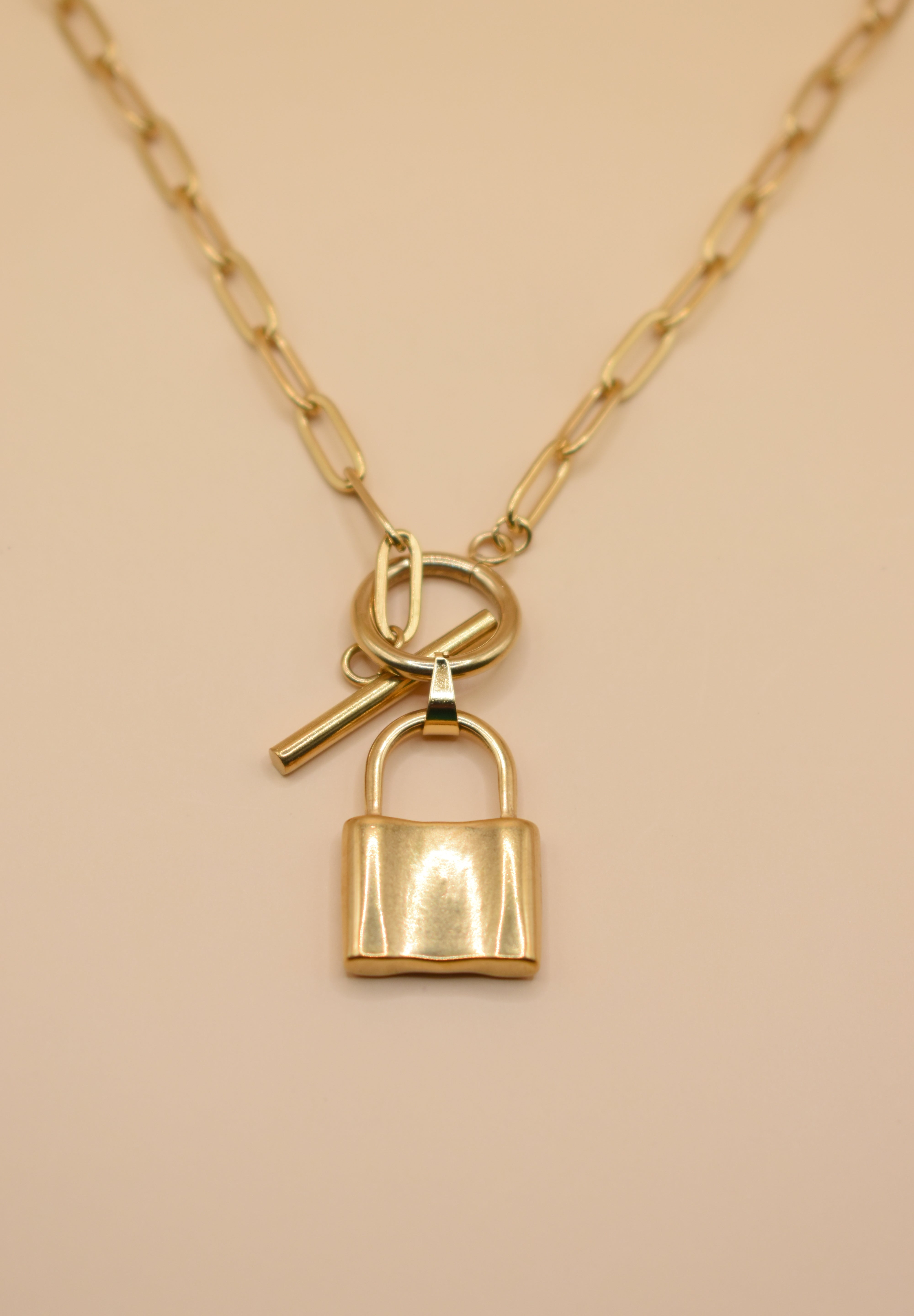 Gold lock pendant necklace on paperclip chain