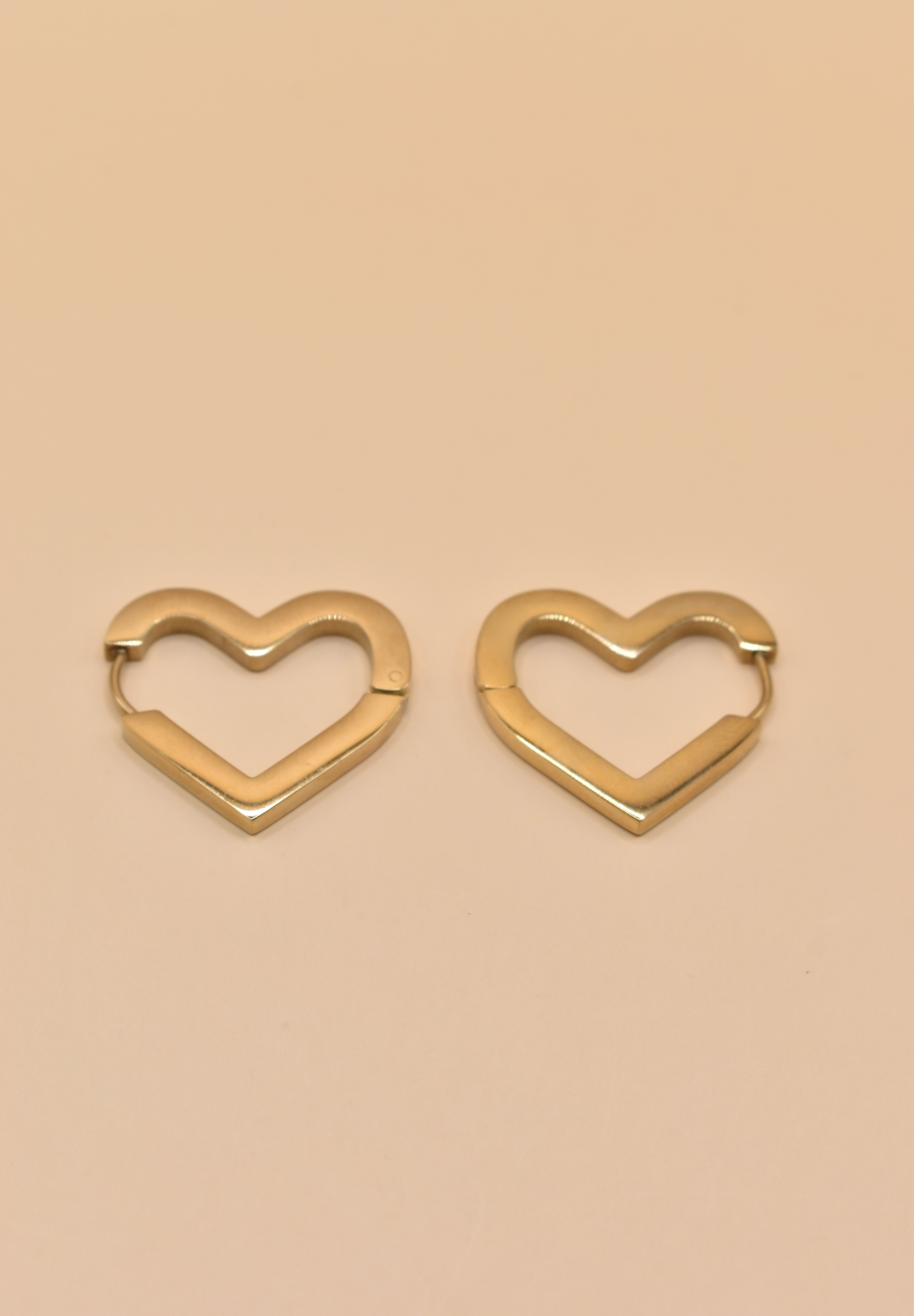 Gold heart charm hoop huggies earrings close-up