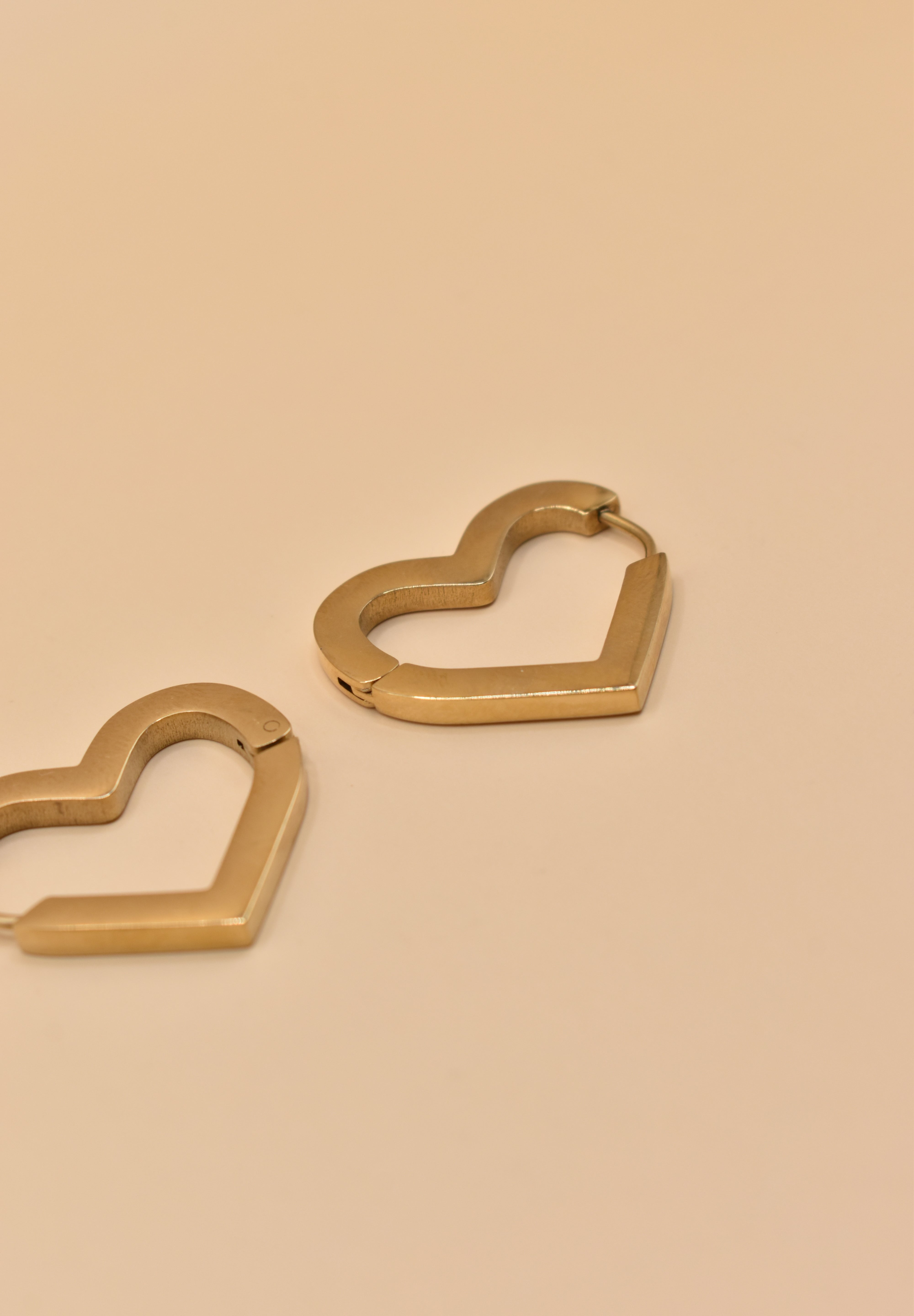 Gold heart charm hoop huggies earrings close-up