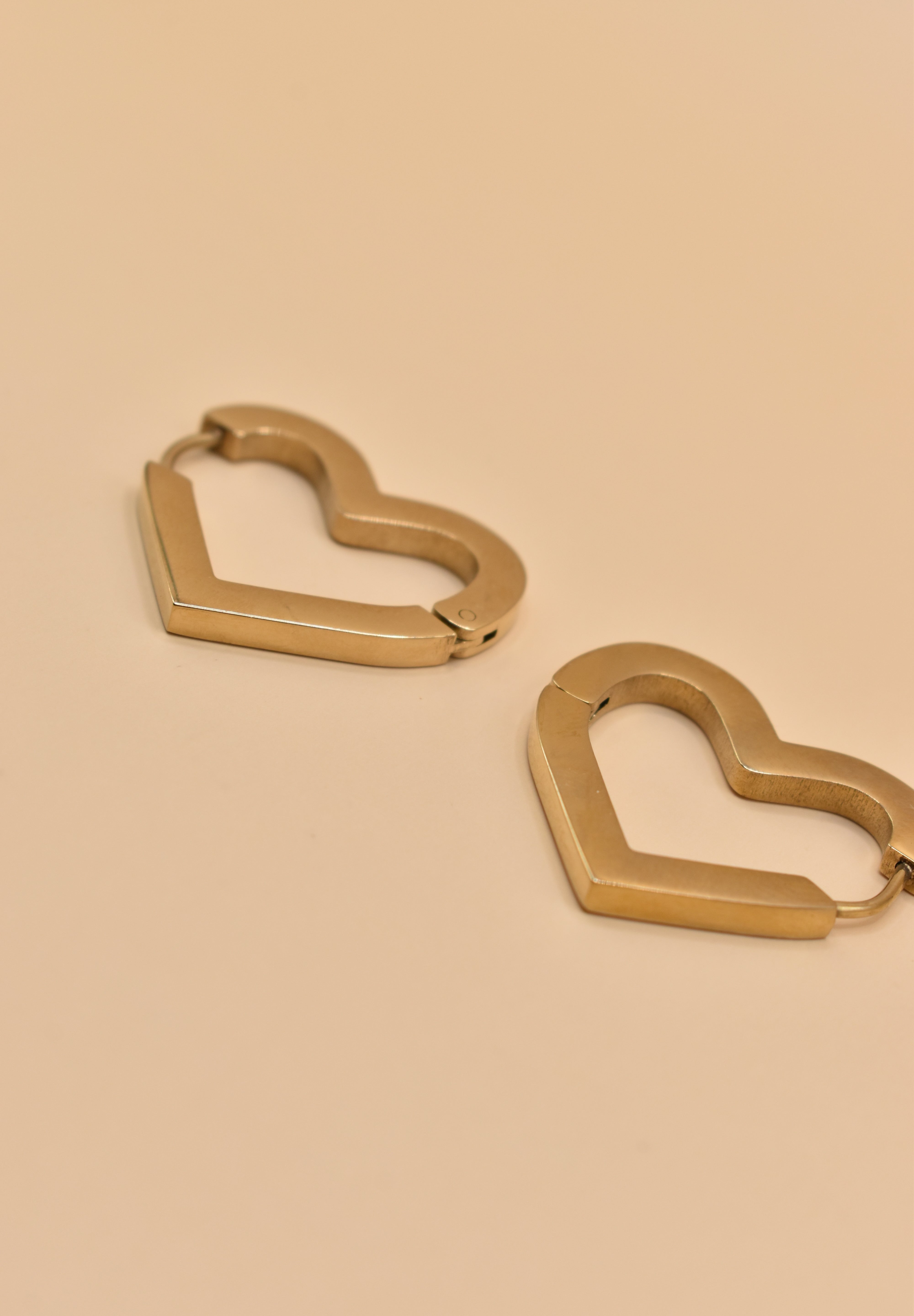 Gold heart charm hoop huggies earrings close-up