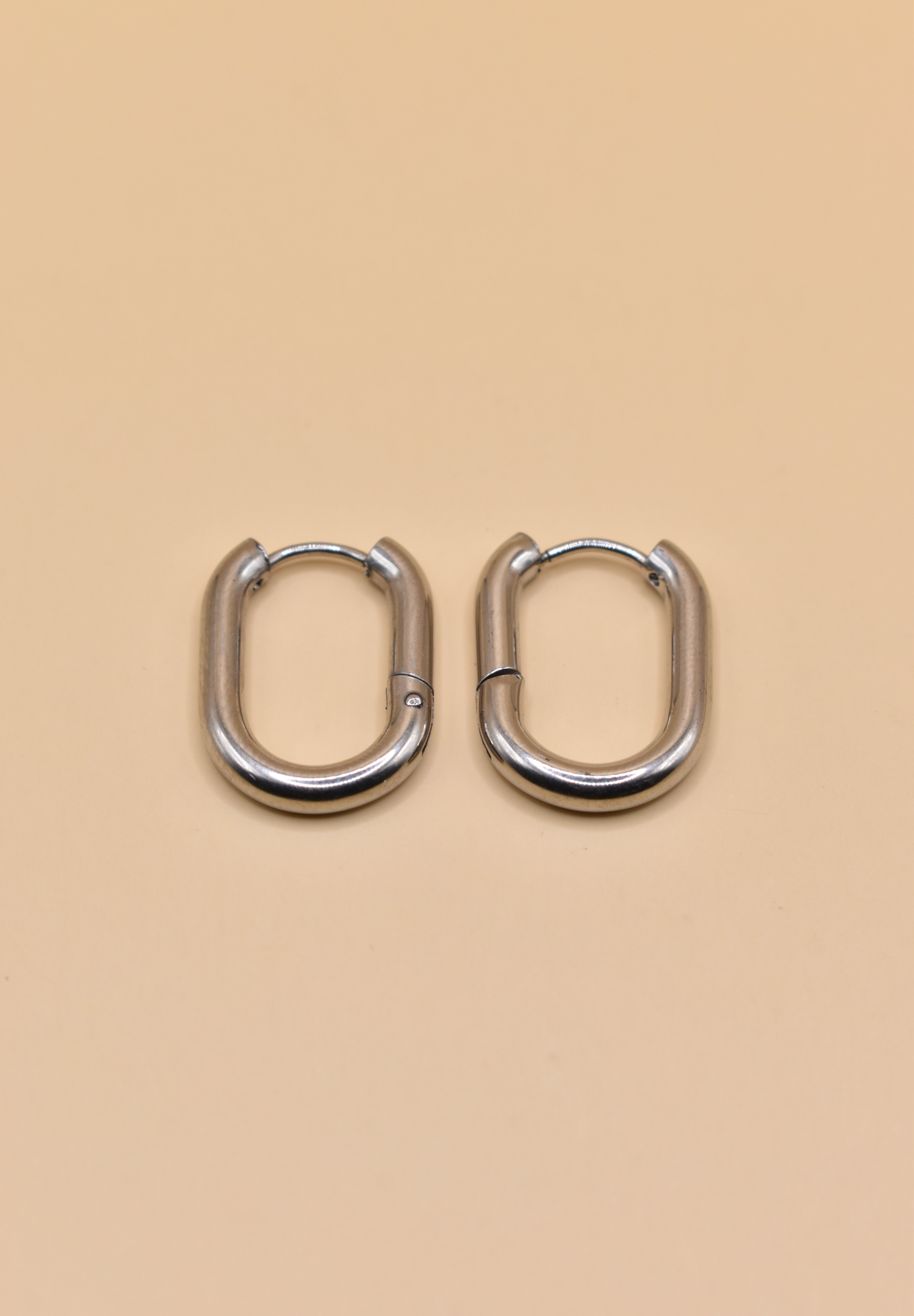 18K gold oval huggie hoop earrings with polished finish