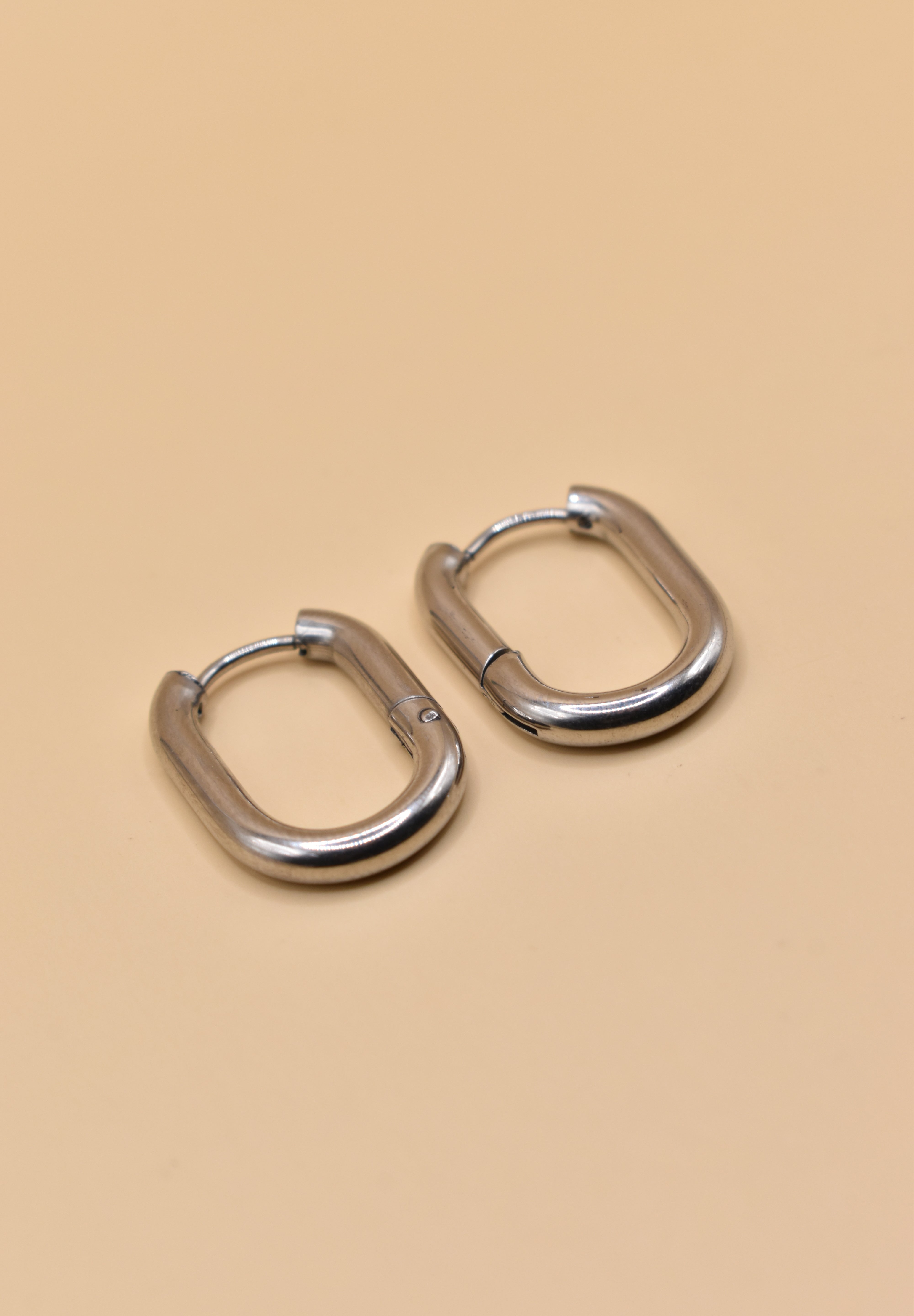 18K gold oval huggie hoop earrings with polished finish