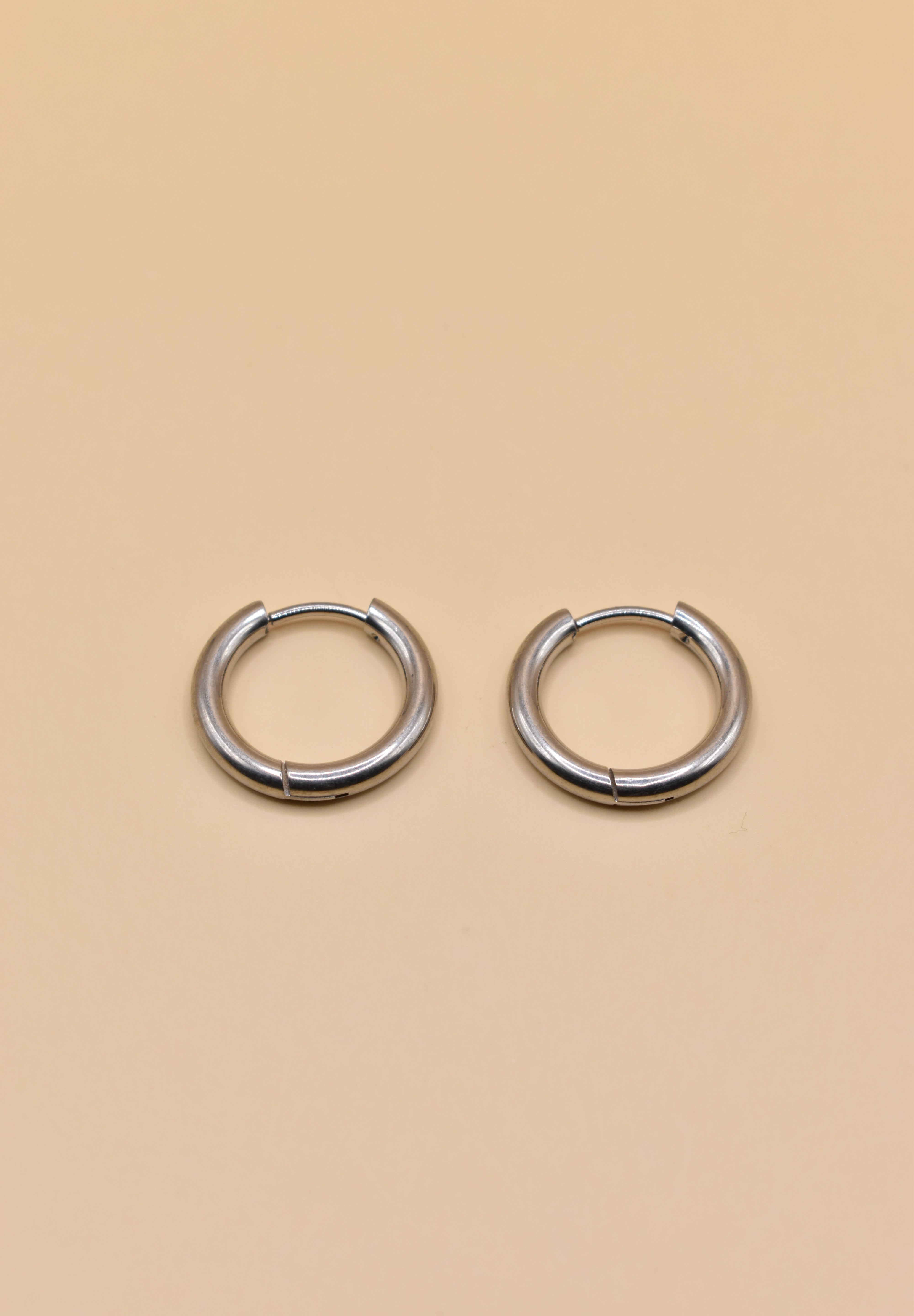 Gold circle huggie hoop earrings on white background