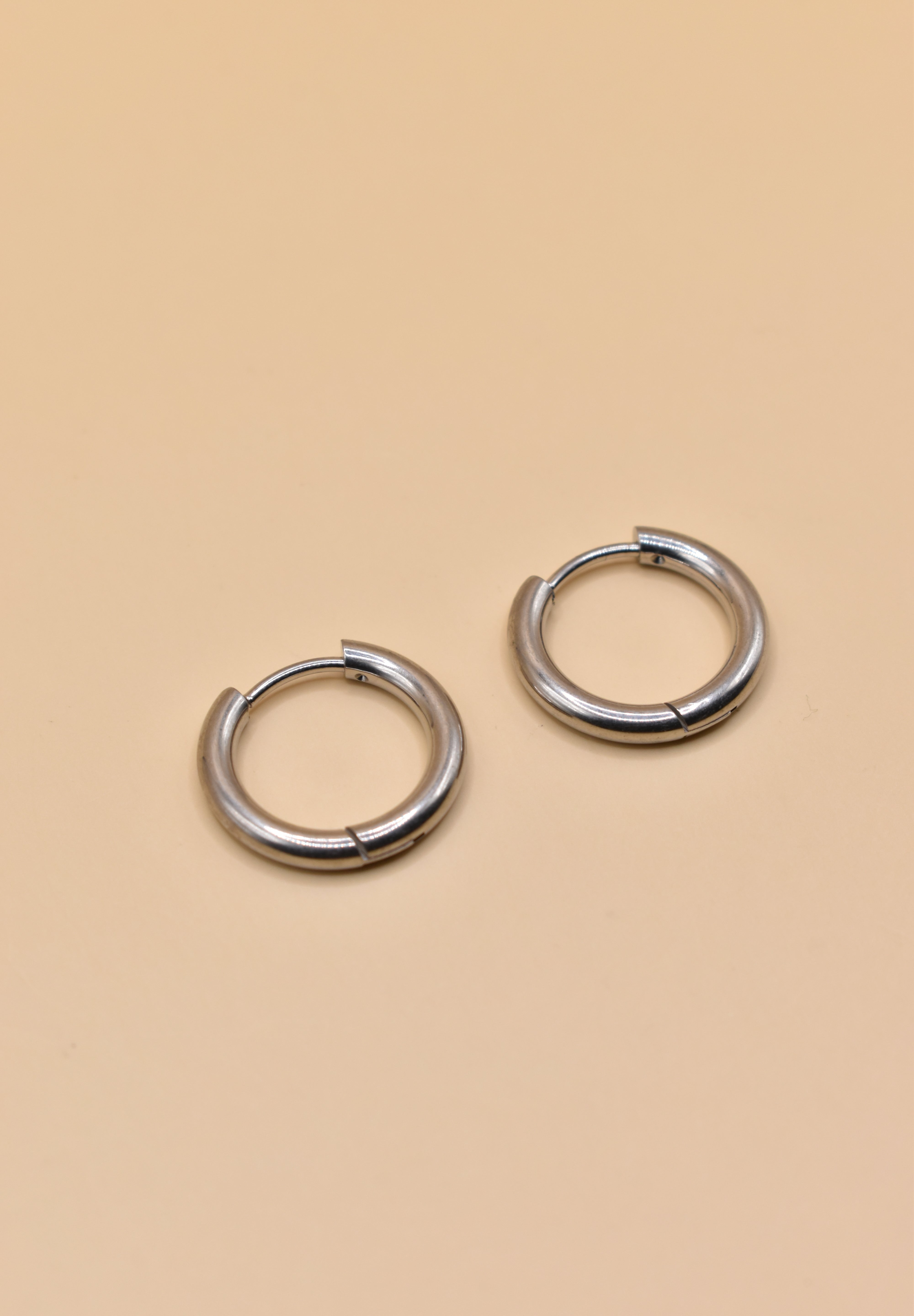 Gold circle huggie hoop earrings on white background