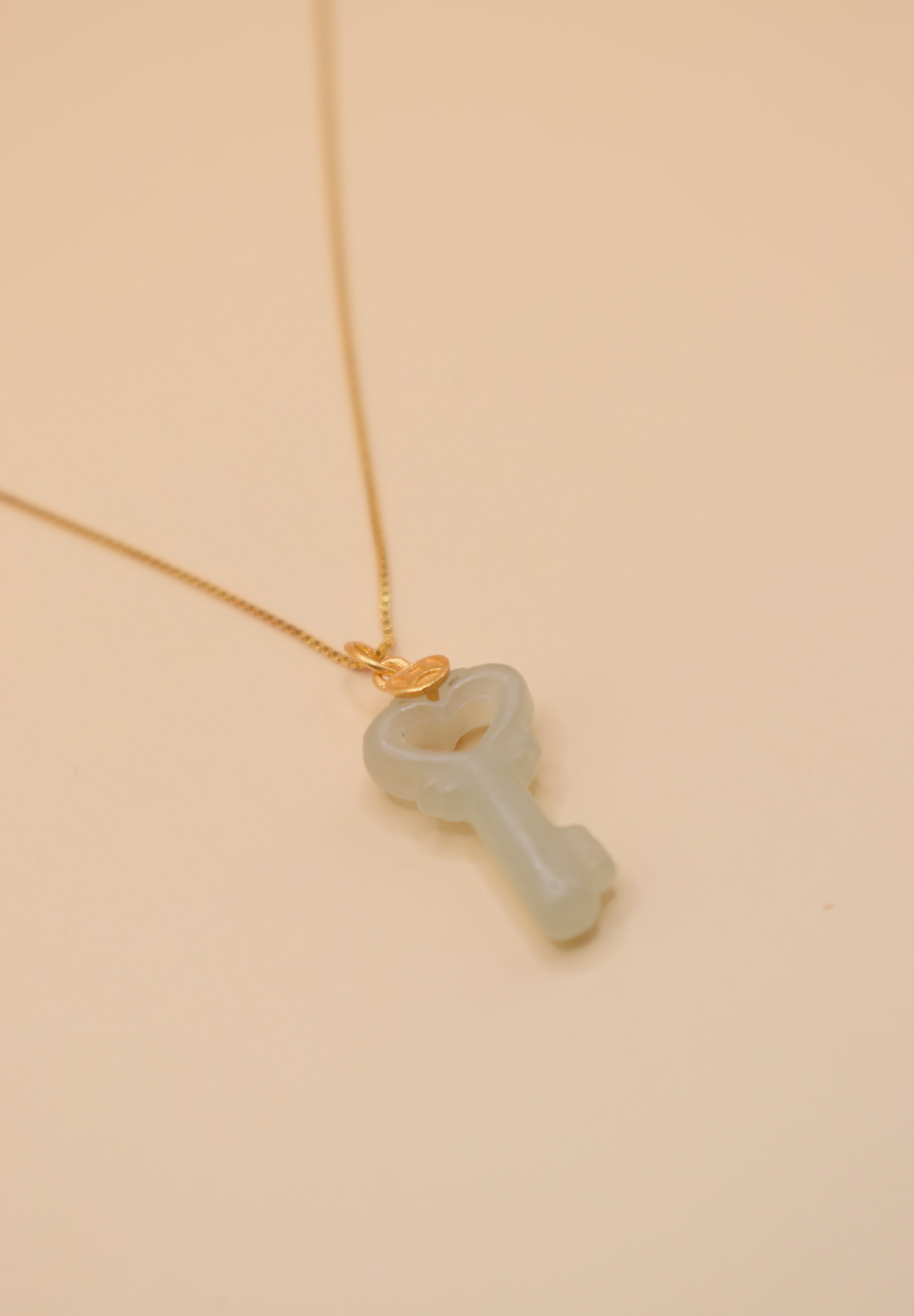 Gold key pendant necklace with jade charm on dainty chain