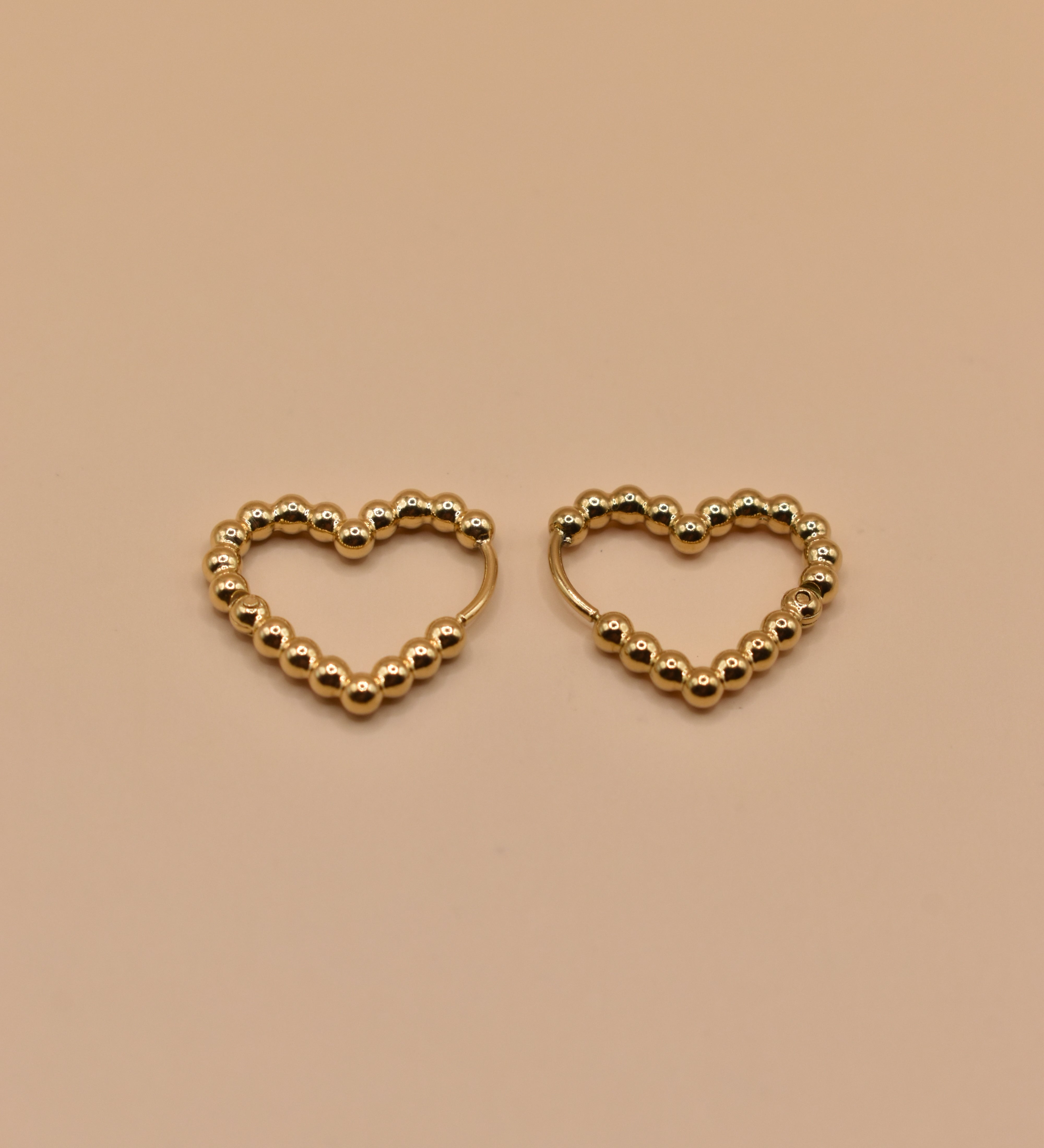 Gold heart huggies hoop earrings with charm design
