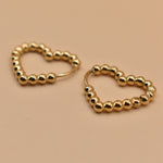 Gold heart huggies hoop earrings with charm design