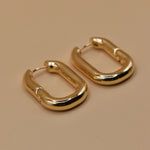 Gold U Huggies Earrings with curved hoop charm design