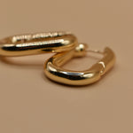 Gold U Huggies Earrings with curved hoop charm design
