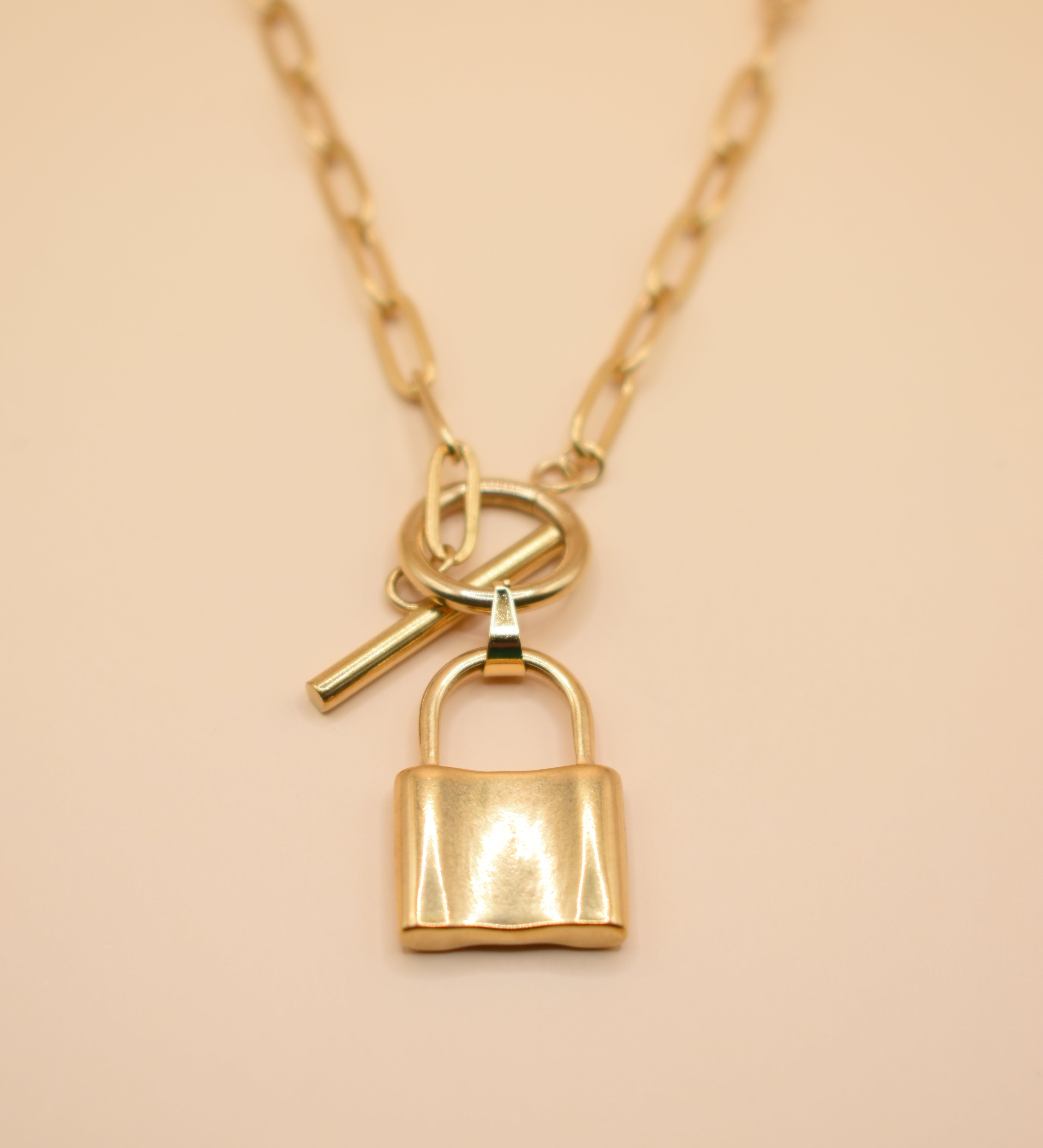 Gold lock pendant necklace on paperclip chain