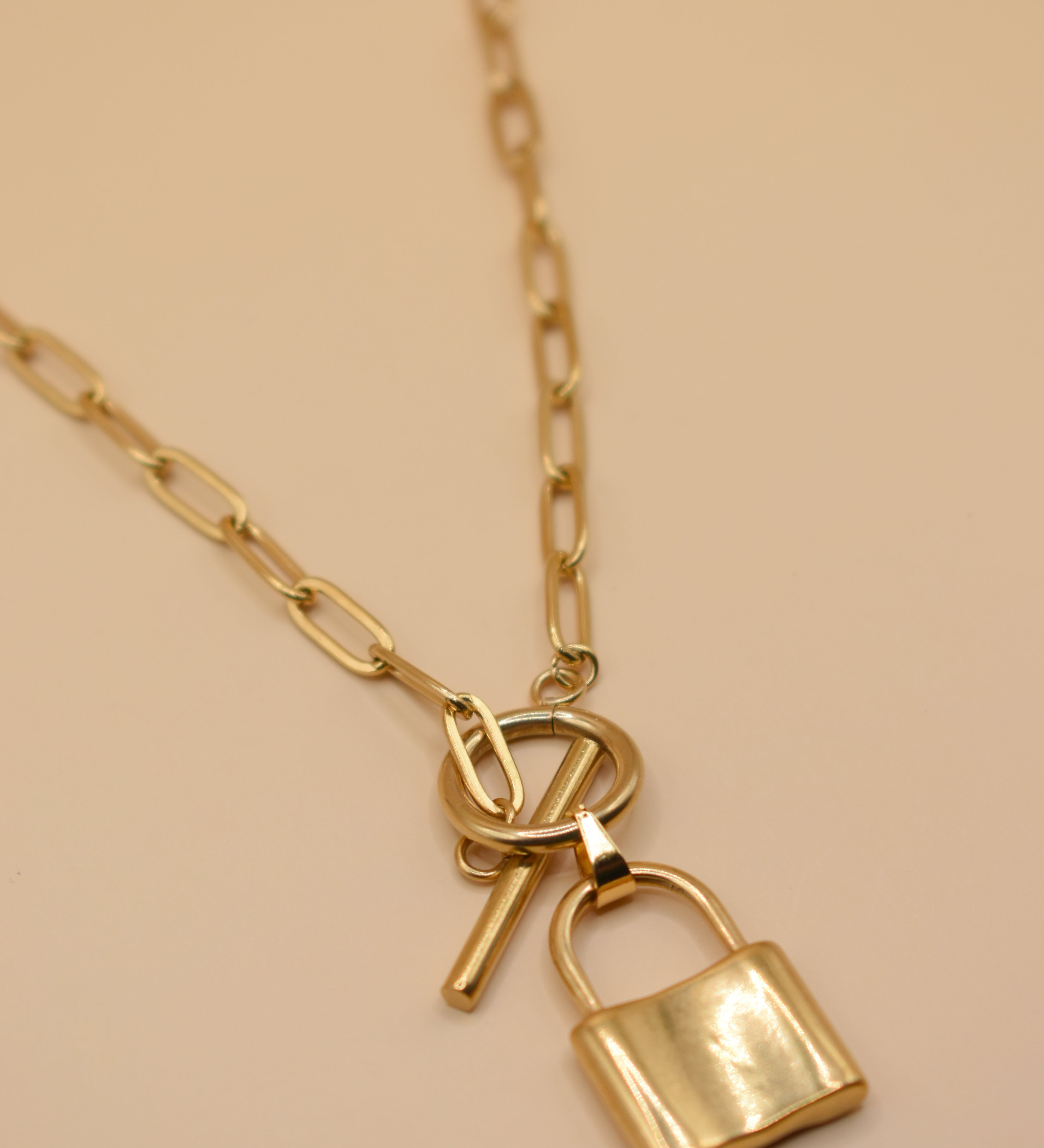 Gold lock pendant necklace on paperclip chain