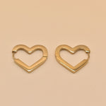 Gold heart charm hoop huggies earrings close-up