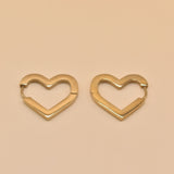 Gold heart charm hoop huggies earrings close-up