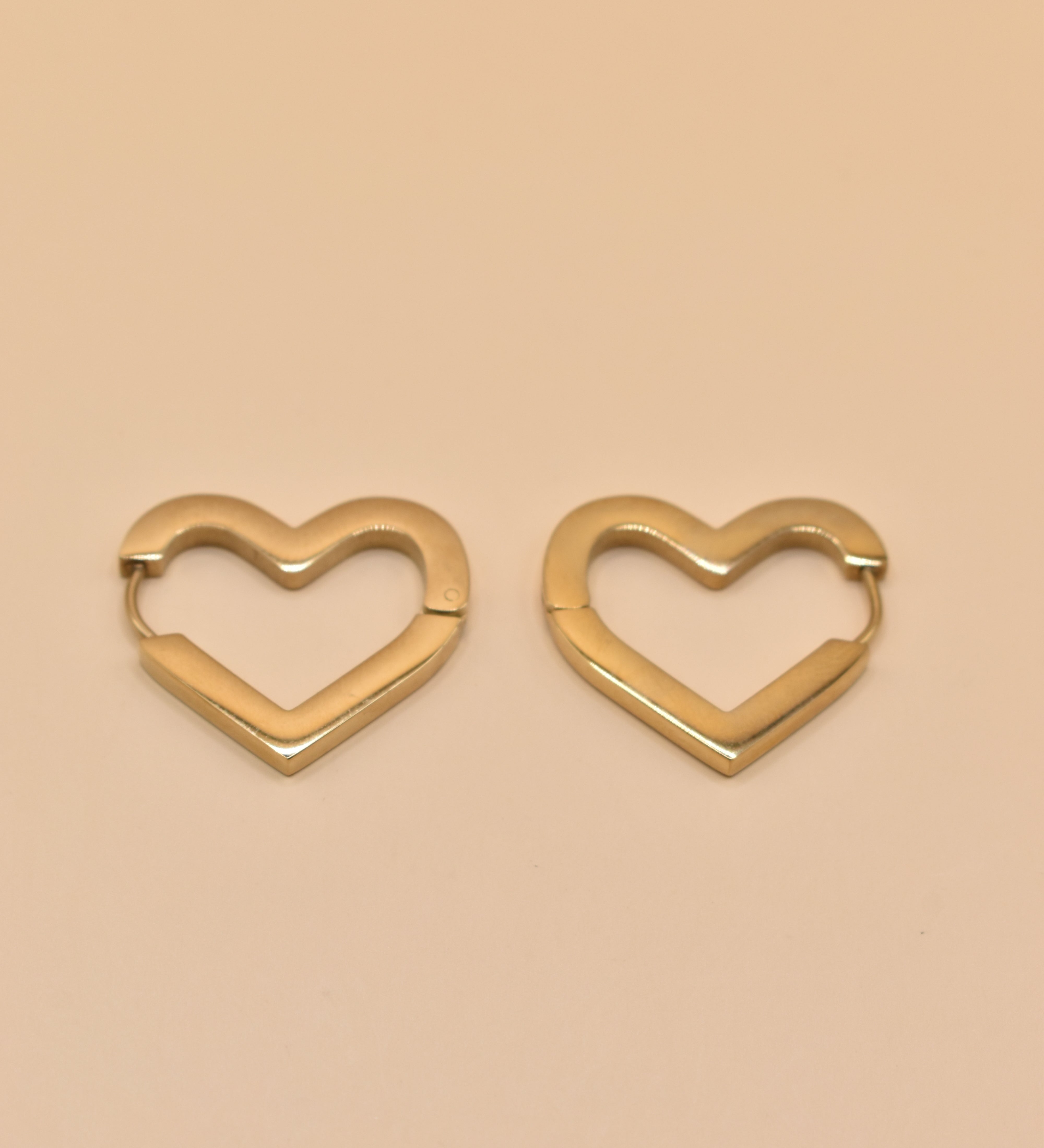Gold heart charm hoop huggies earrings close-up
