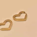 Gold heart charm hoop huggies earrings close-up