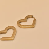 Gold heart charm hoop huggies earrings close-up
