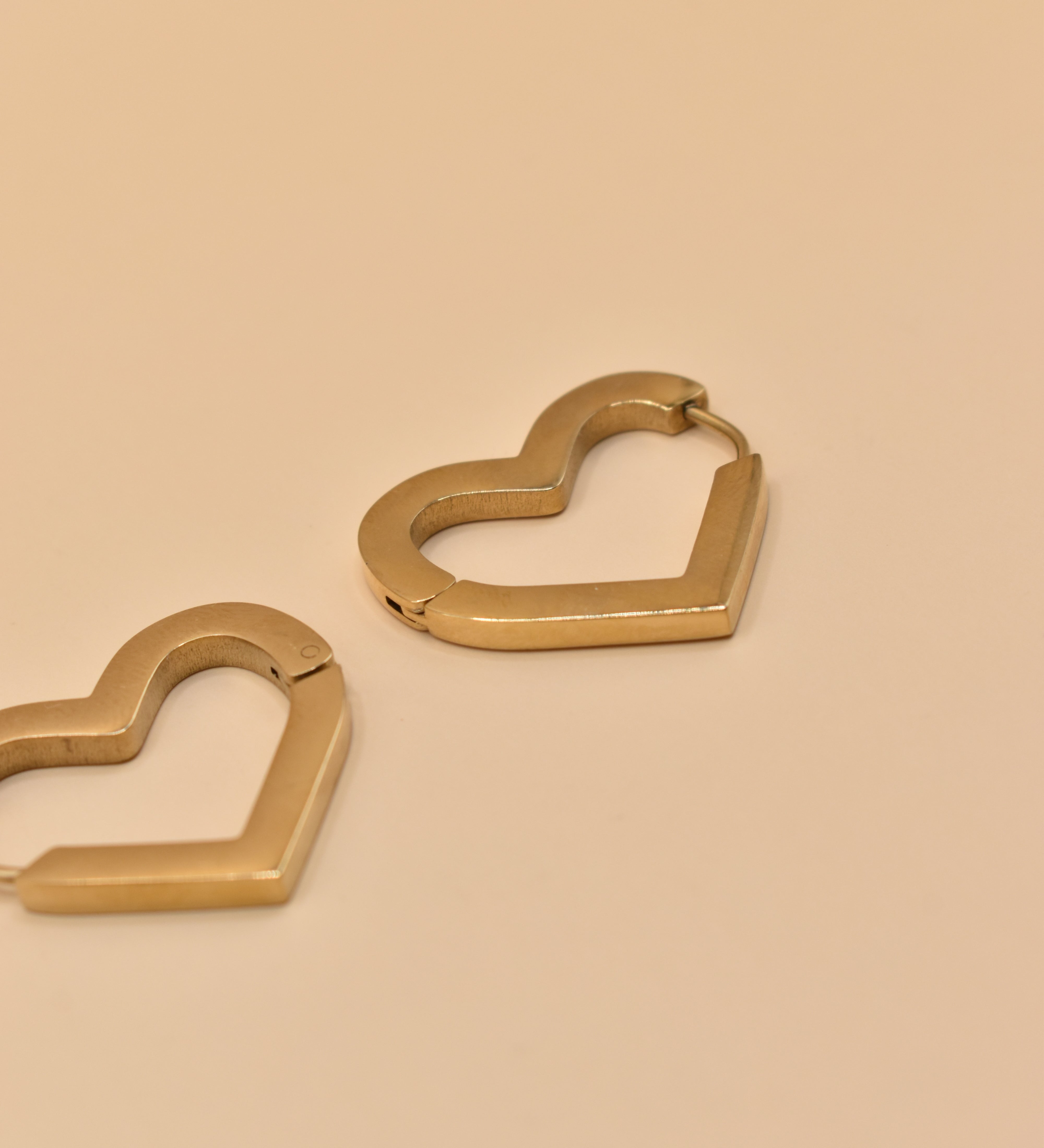 Gold heart charm hoop huggies earrings close-up