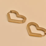 Gold heart charm hoop huggies earrings close-up