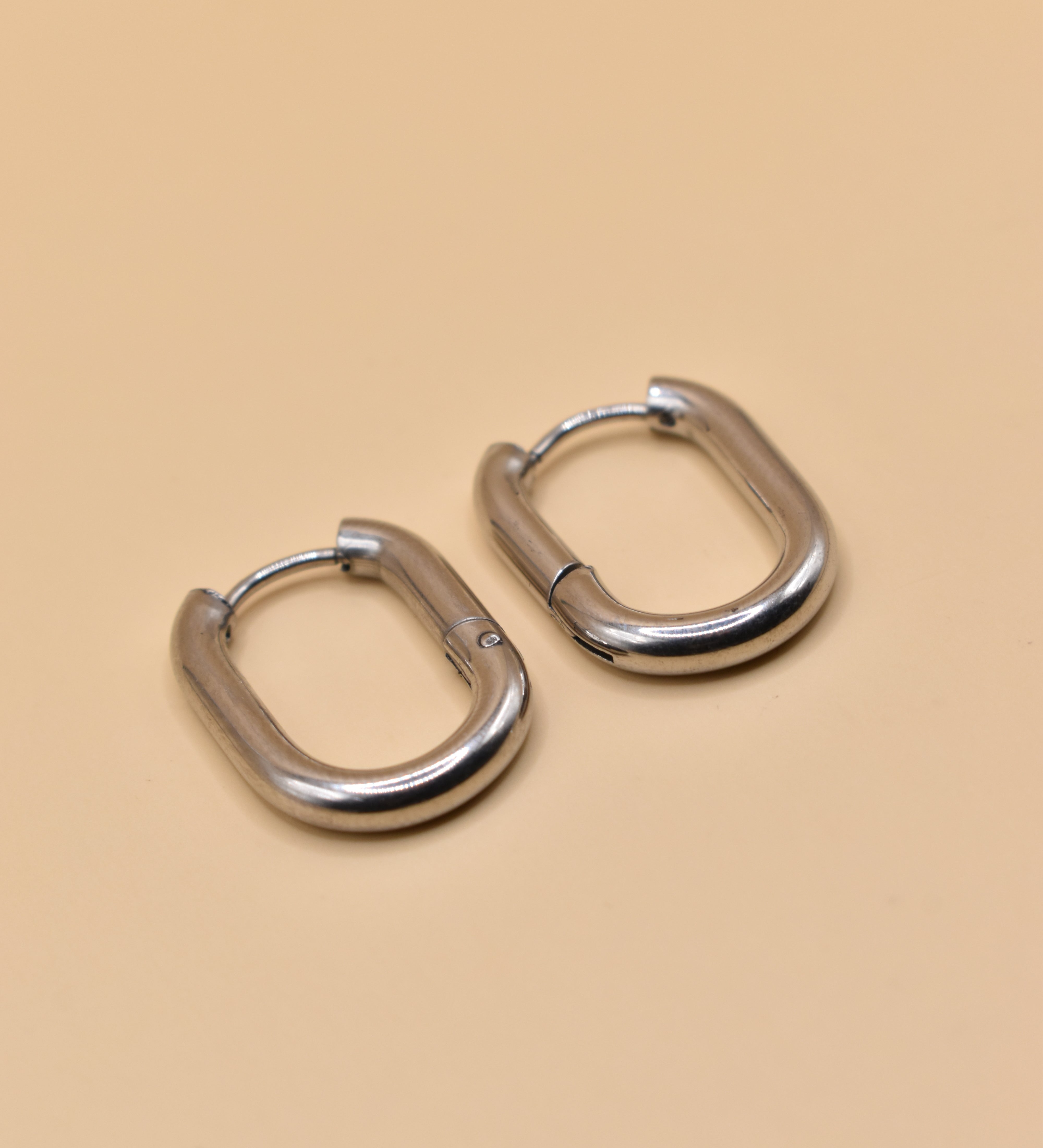 18K gold oval huggie hoop earrings with polished finish