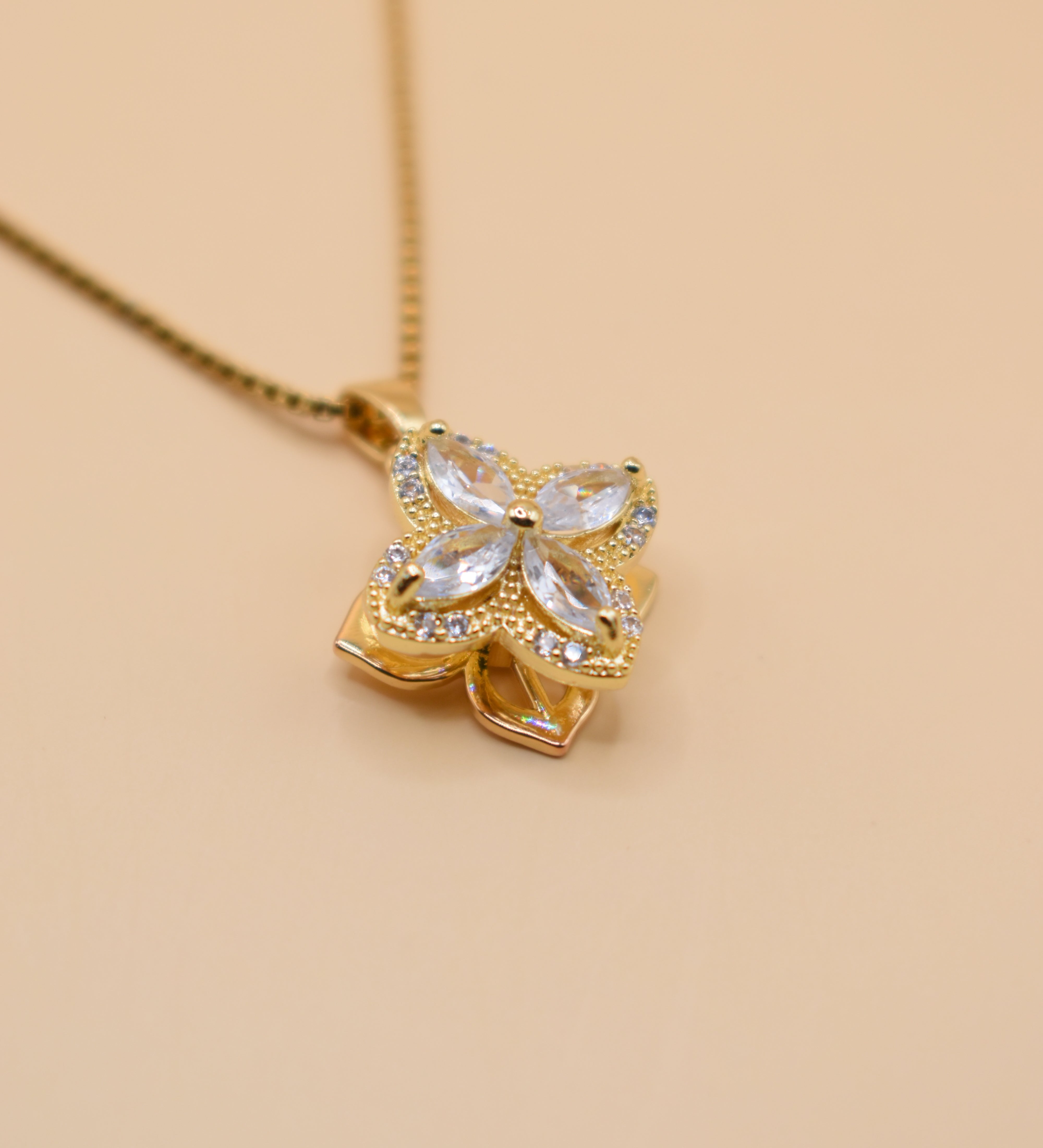 Gold clover pendant necklace with rotating charm